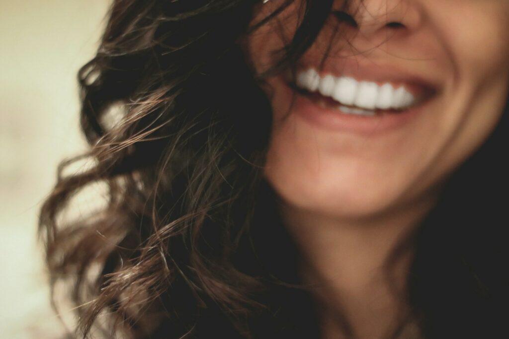 long black haired woman smiling close-up photography