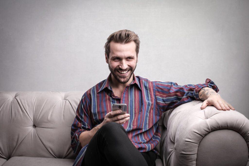 Man in Striped Long Sleeve Using Mobile Phones