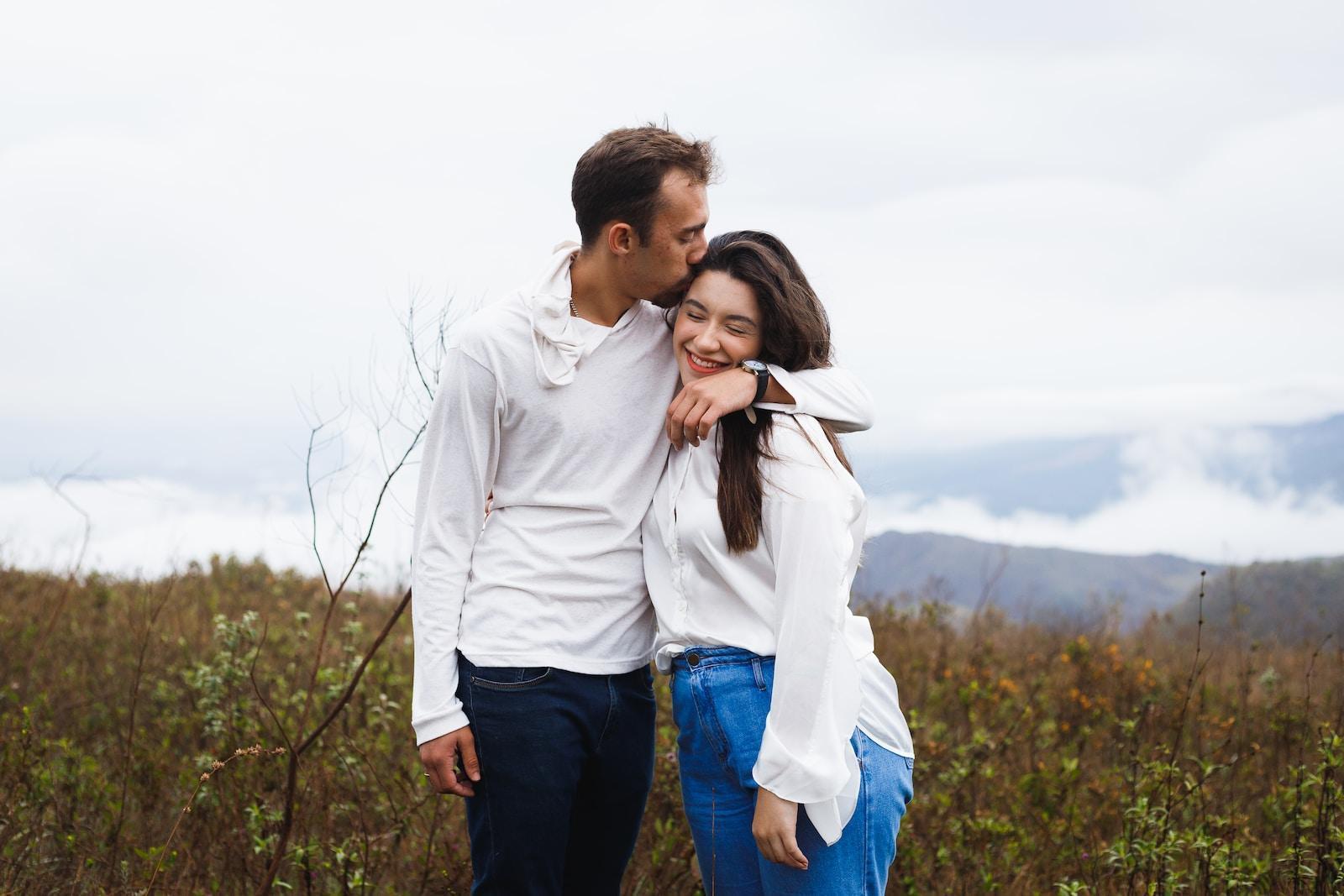 a man and a woman standing next to each other in a field