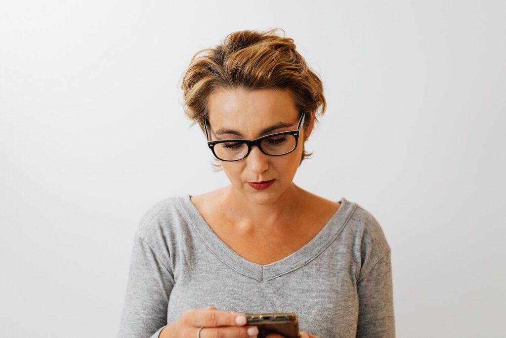 Woman in Gray V Neck Shirt Wearing Black Framed Eyeglasses