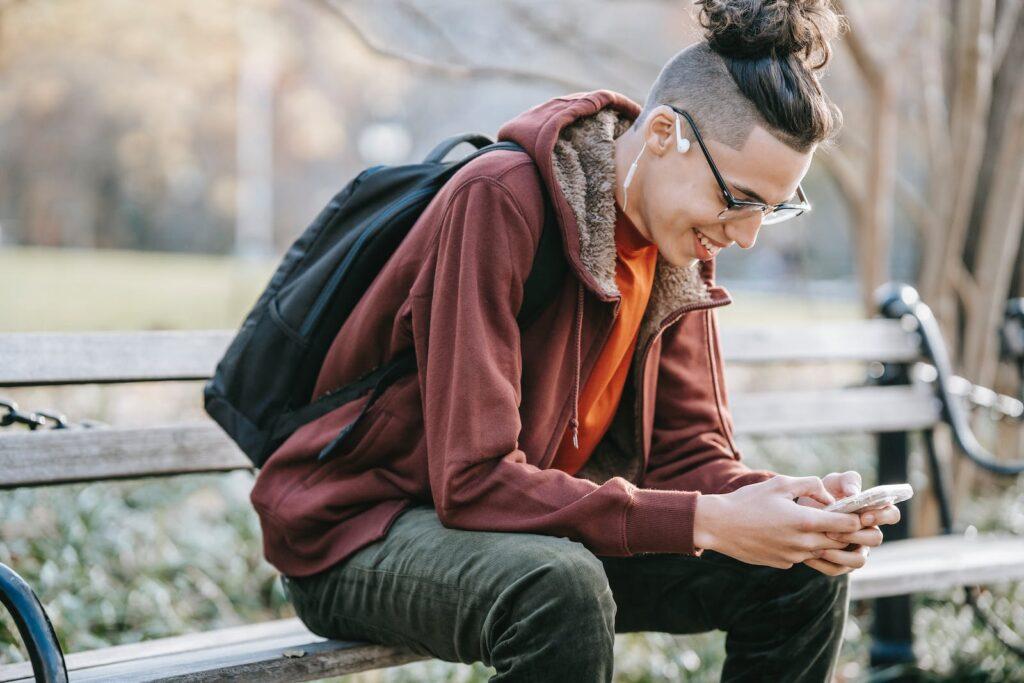 Cheerful man with smartphone in park