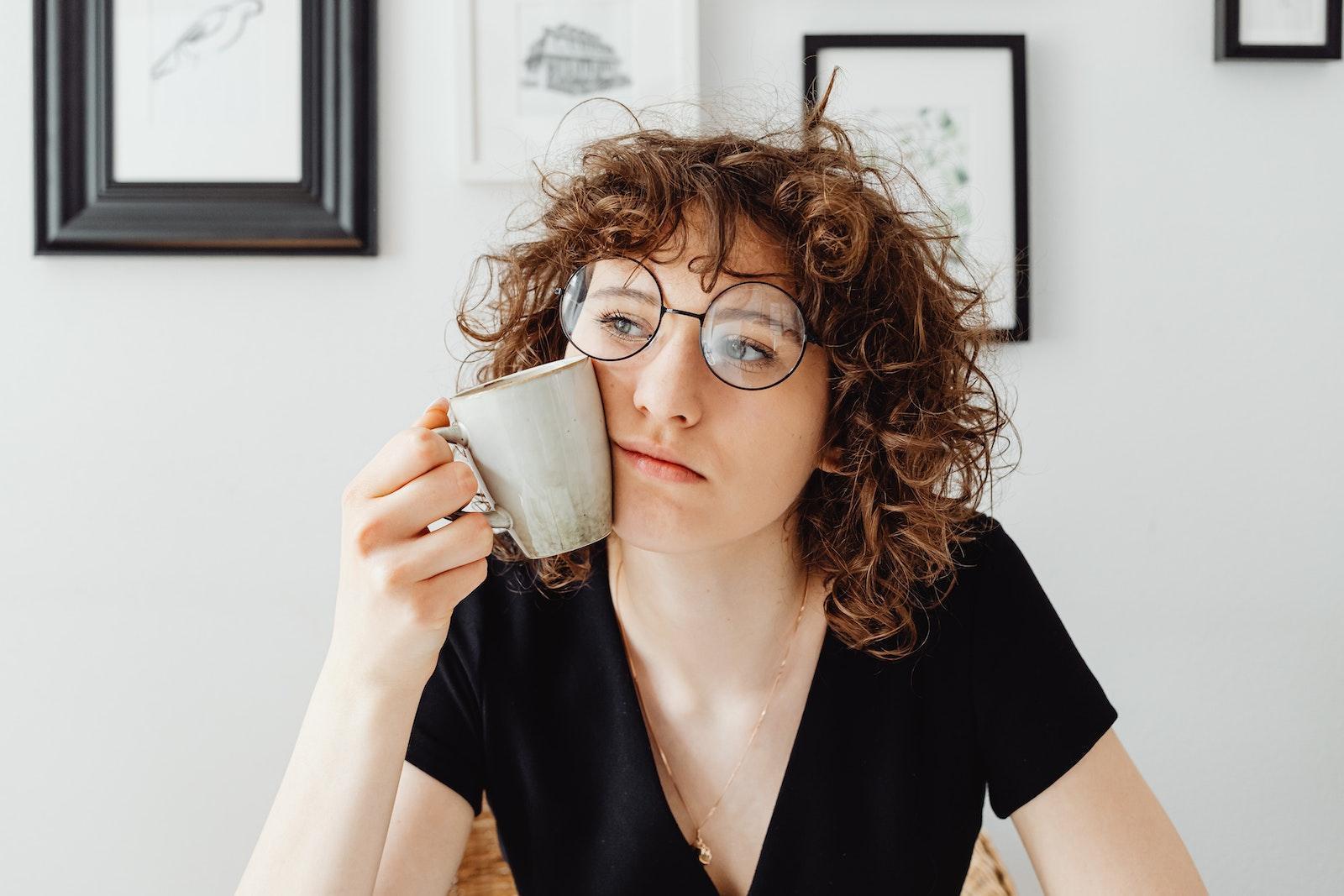 Curly-Haired Woman Holding a Coffee Mug