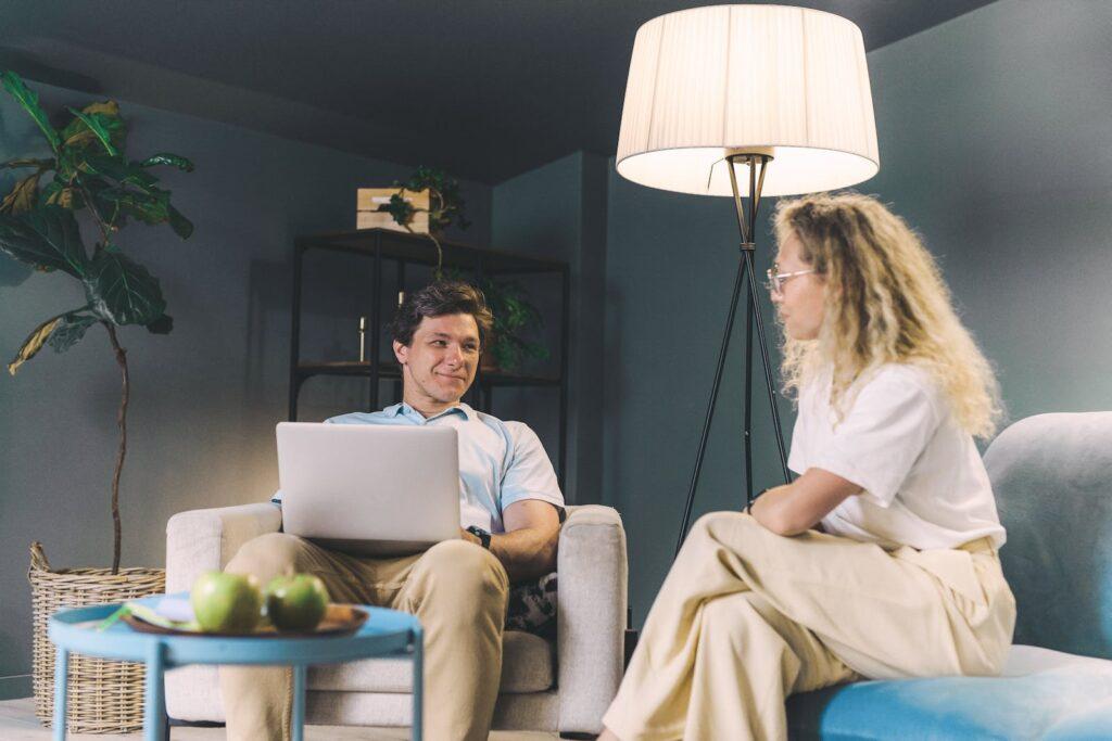 Woman in White Long Sleeve Shirt Sitting on Gray Couch