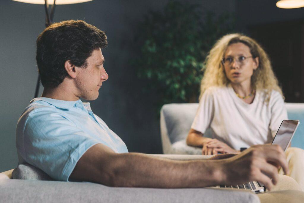 Man in White Crew Neck T-shirt Sitting Beside Woman in White Crew Neck T-shirt