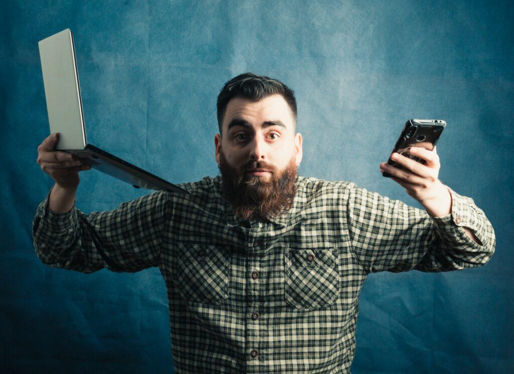 man in black and white plaid dress shirt holding black smartphone