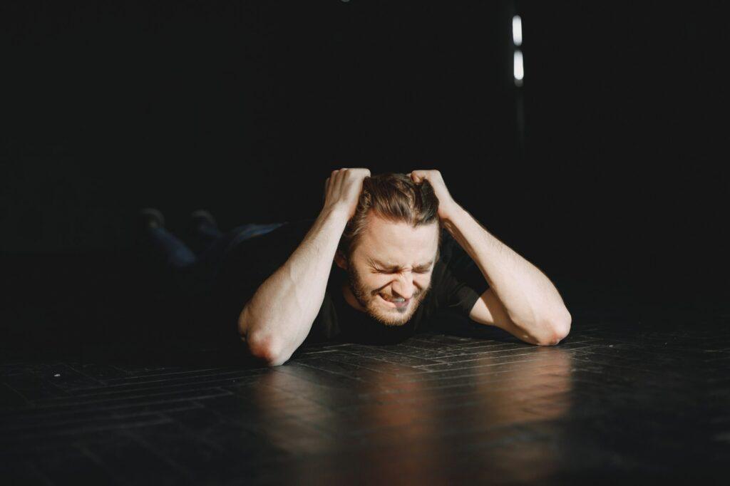 Drug addict laying on the floor in agony