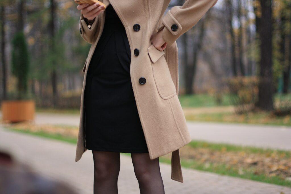 woman in brown coat standing on road during daytime