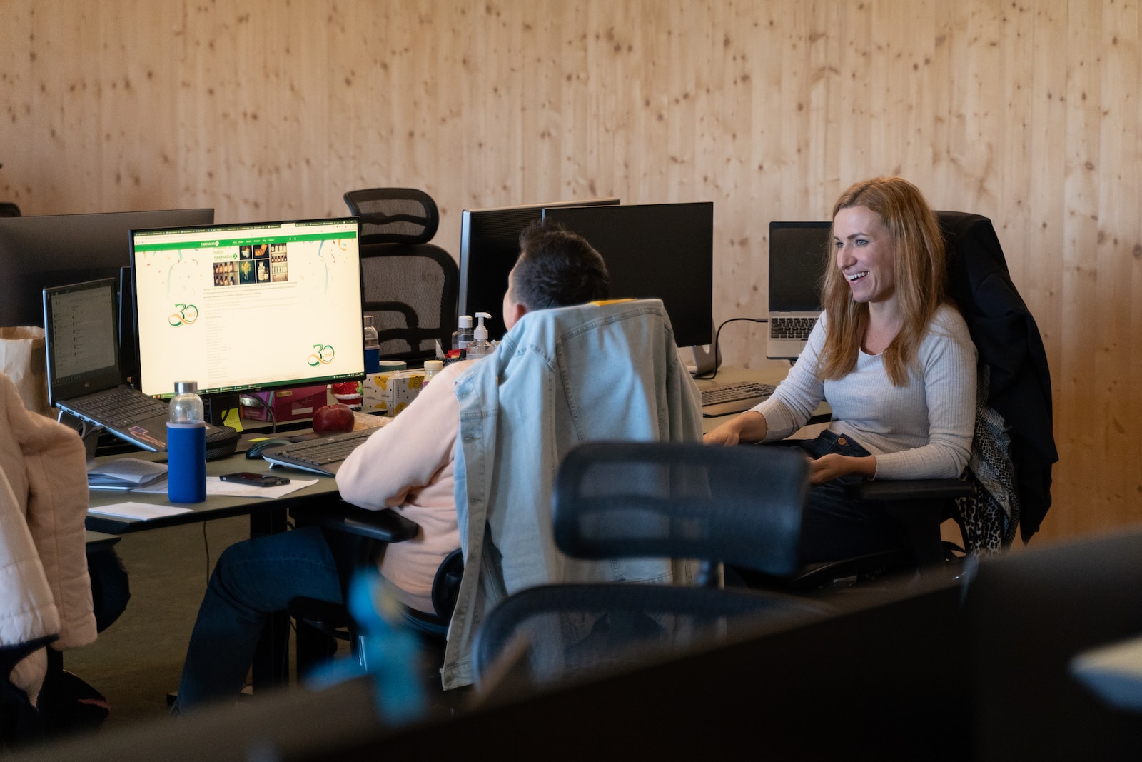 a woman sitting at a desk in front of a computer