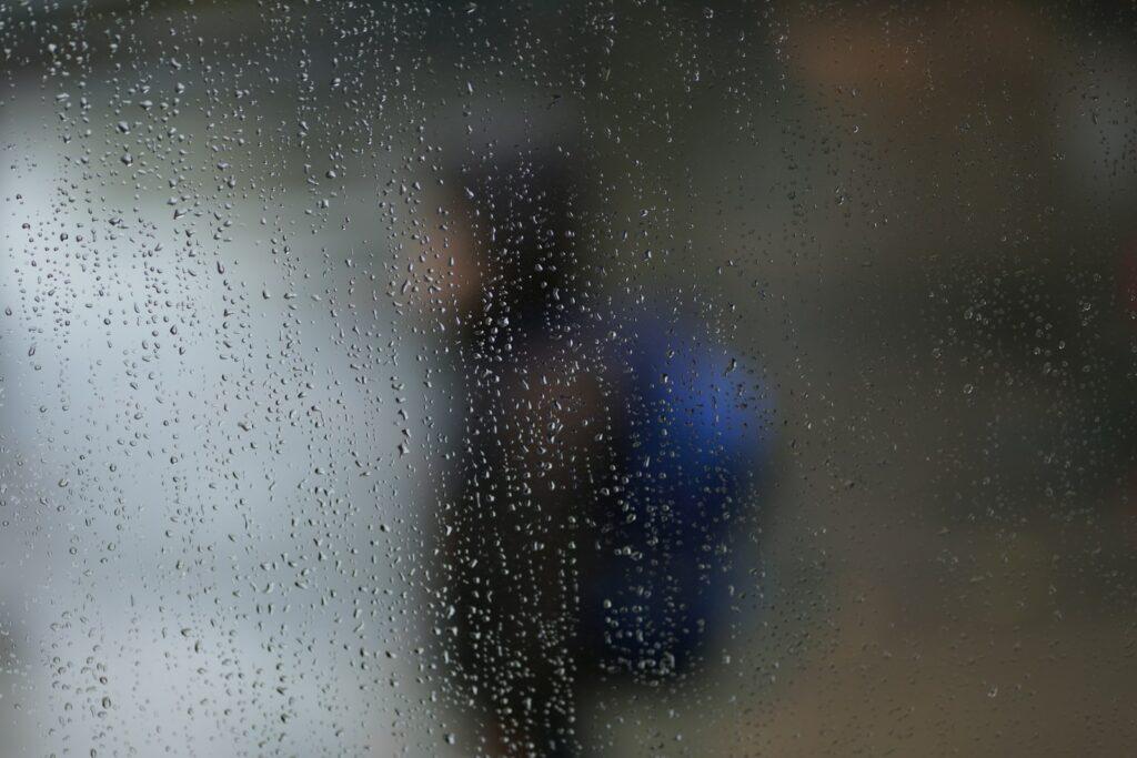 a blurry image of a person standing in the rain