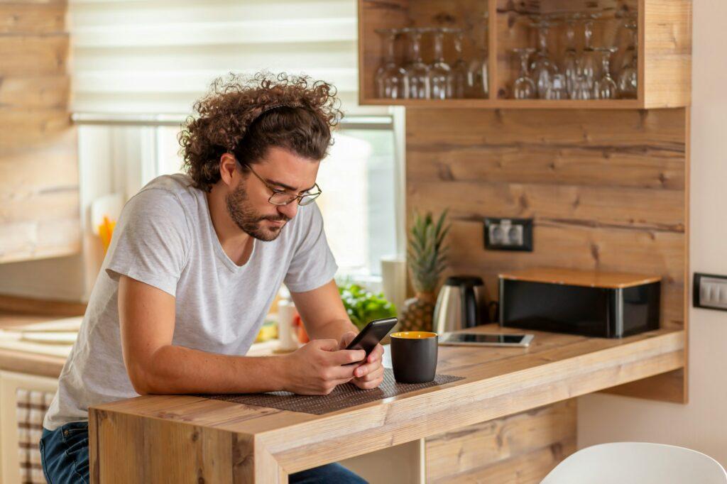 Man typing a text message using smart phone