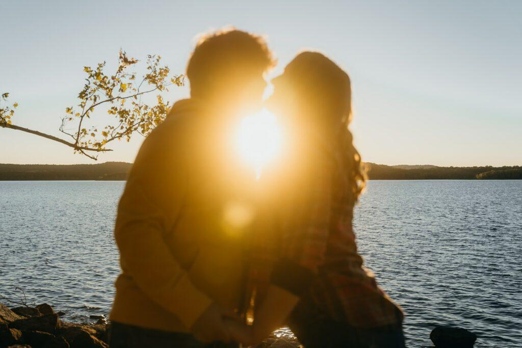 a man and a woman standing next to a body of water