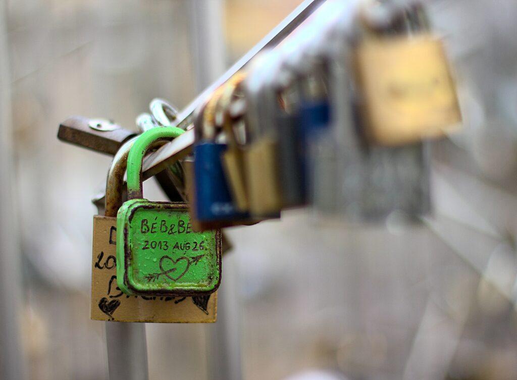 a bunch of padlocks attached to a metal pole